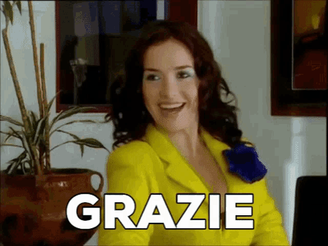 a woman in a yellow suit says grazie in a room