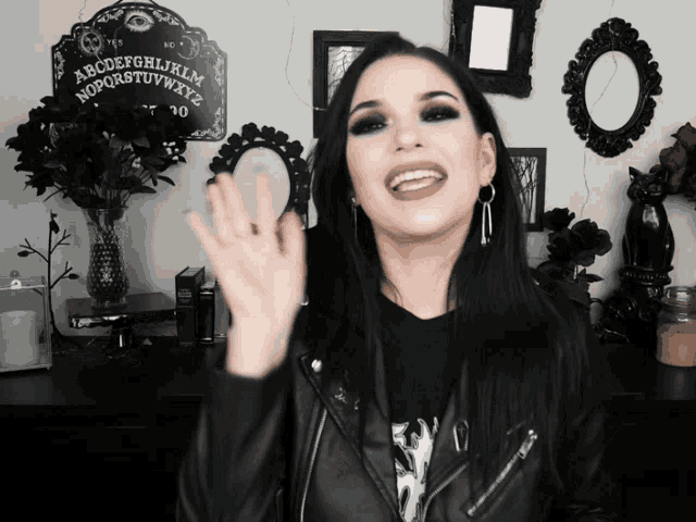 a woman is smiling in front of a ouija board
