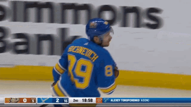 a hockey player in a blue jersey with the number 19 on it