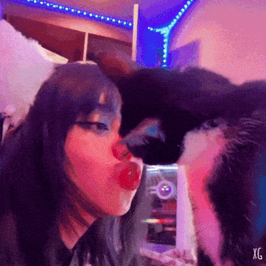 a painting of a girl kissing a black cat with the letters xg on the bottom