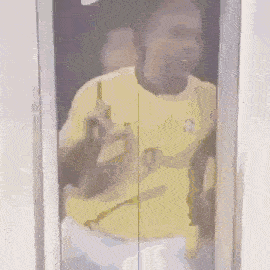 a man in a yellow shirt with the number 9 on it is standing in an elevator
