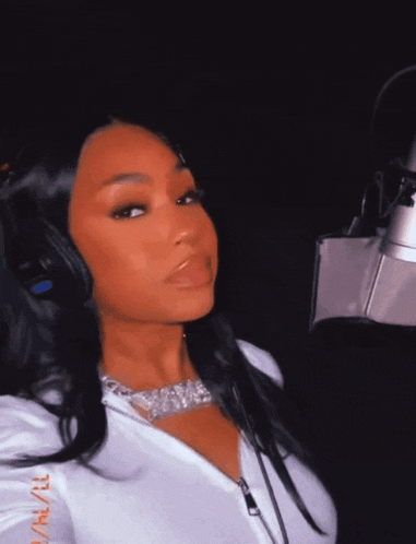 a woman wearing headphones is standing in front of a microphone with a photo taken on january 21st