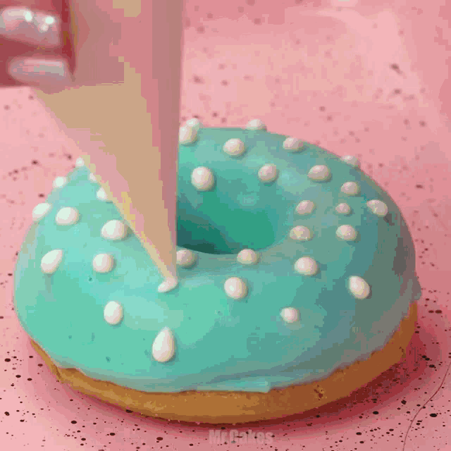 four different colored donuts on a pink tray with the words mr.cakes below them