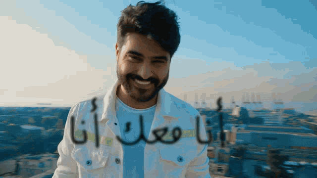 a man with a beard is smiling in front of a city
