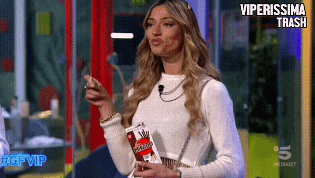 a woman is holding a bag of micado chips