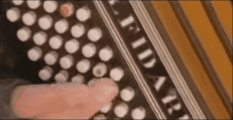 a person is playing an accordion with their finger on the buttons .