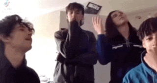 a group of young people are standing in a room with their arms crossed .