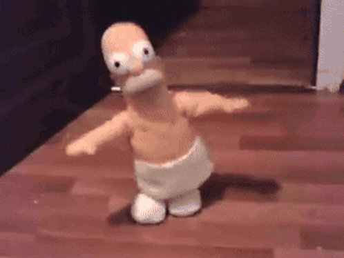 a stuffed homer simpson dancing on a wooden floor