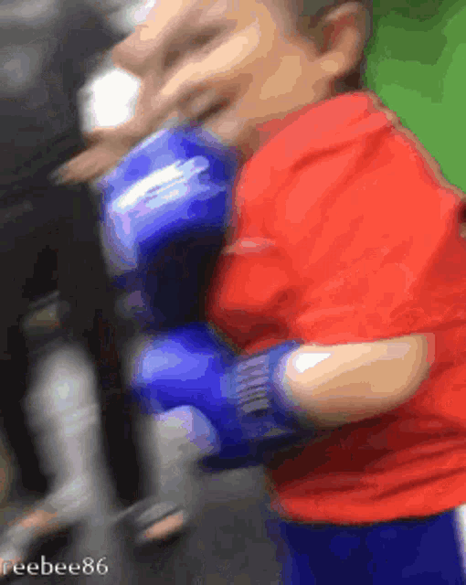 a blurry picture of a person wearing blue boxing gloves with the number 86 on the bottom