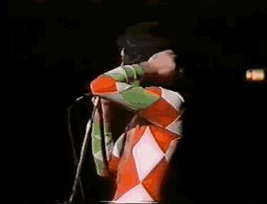 a man singing into a microphone with his arms outstretched
