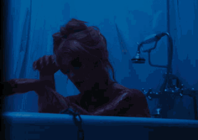 a woman in a bathtub with blood on her arms