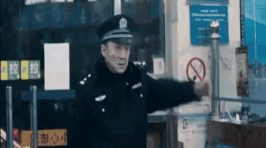 a man in a police uniform stands in front of a sign that says no smoking