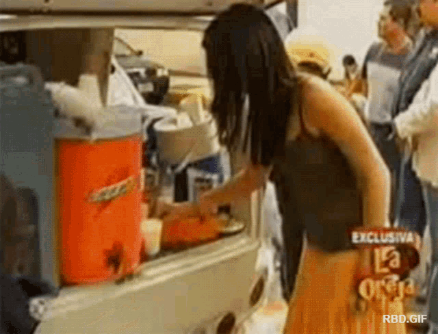 a woman is standing in front of a vending machine that says ' exclusive ' on the top