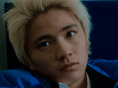 a close up of a person 's face with a blue background