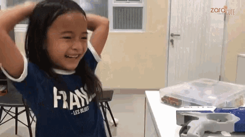 a little girl wearing a blue shirt that says frans on it