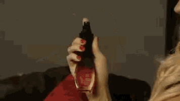 a woman is sitting on a couch holding a spray bottle
