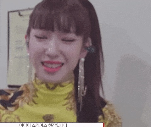 a close up of a woman wearing a yellow top and earrings