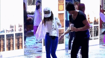 a woman wearing a hat that says run is dancing with a man in a black shirt
