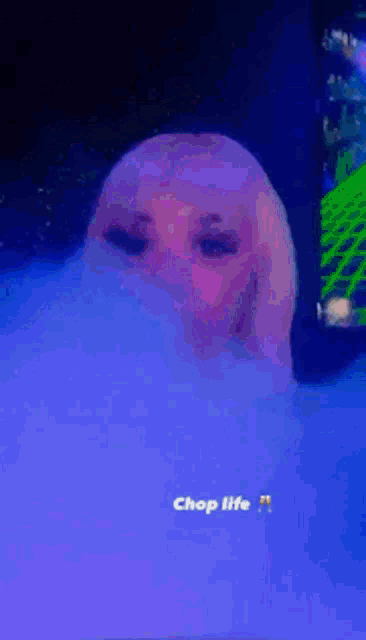 a woman is smoking a hookah in a dark room and the caption says chop life
