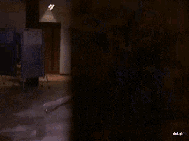 a woman in an orange crop top is standing in a dark room