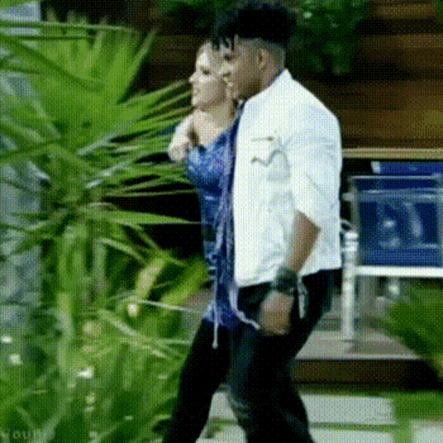 a man and a woman are standing next to each other in front of a building .