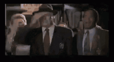 a man in a suit covering his face with his hand