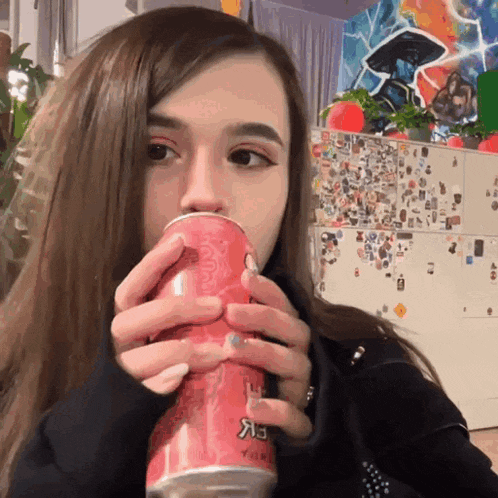 a girl drinking from a can that says coca cola on it