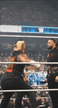 two wrestlers are fighting in a ring with a crowd watching