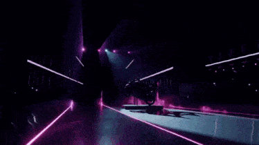 a person is doing a trick on a motorcycle on a stage in a dark room .