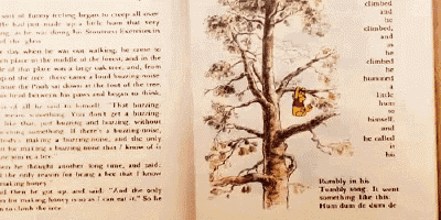 a book is open to a page with a picture of winnie the pooh in a tree
