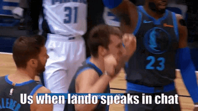 a basketball player wearing number 23 talks to another player