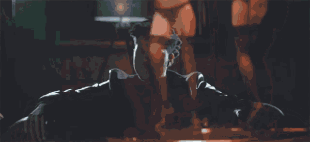 a man and a woman are dancing on a pole in a dark room .