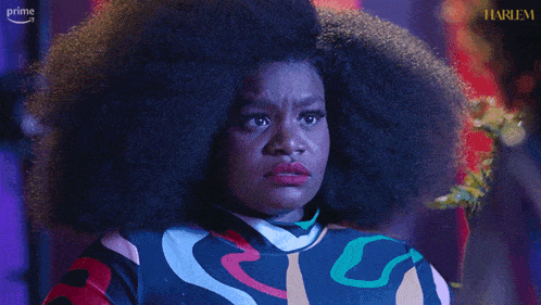 a woman in a colorful dress is crying in front of a harlem logo