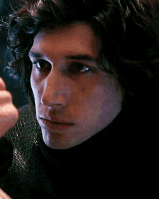 a close up of a man 's face with a woman 's hand touching his face .
