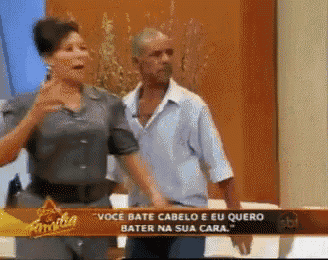 a man and a woman standing in front of a sign that says voce bate cabelo