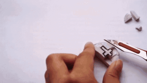 a person is holding a piece of plastic with a cross on it in their hand .