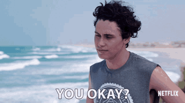 a man standing on a beach with the words " you okay " written on the bottom