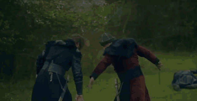 a man with a beard is holding a sword in a field