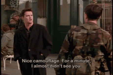 a man in a suit is talking to a man in a camo jacket