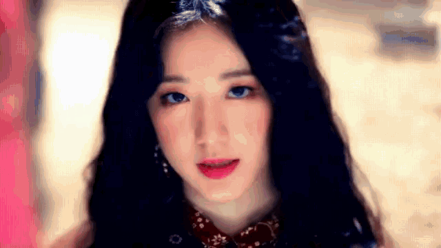 a close up of a woman 's face with long black hair .