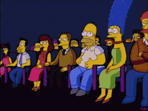 a group of simpsons characters sitting in a theater