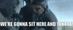 a man in a gas mask is talking to another man in a car .
