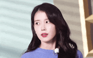 a close up of a woman 's face wearing a blue sweater .