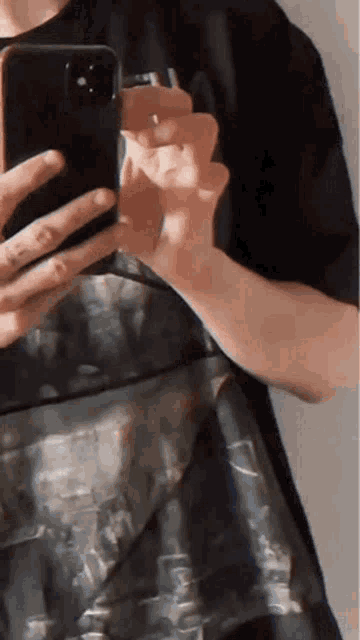 a person is taking a picture of themselves in the mirror with their phone .