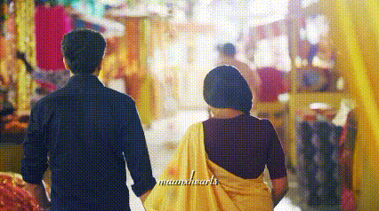 a man and a woman are walking down a street holding hands
