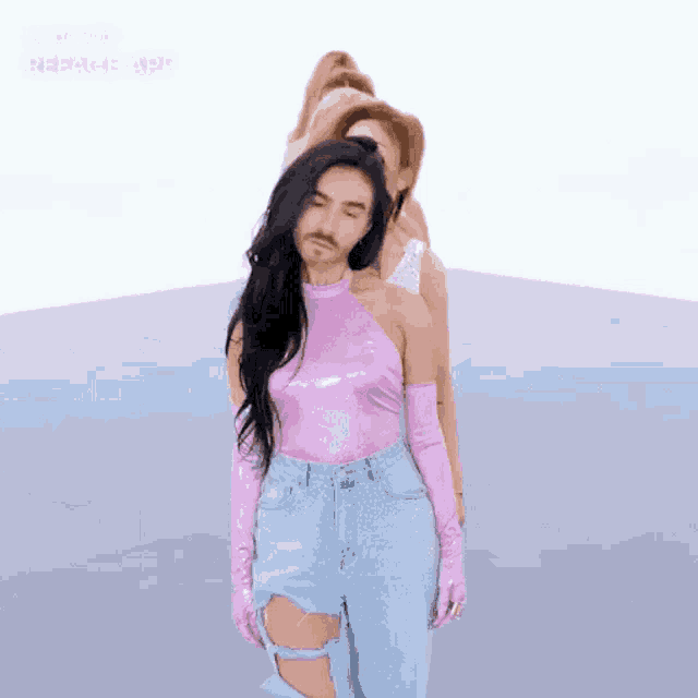 a man with a beard is standing next to a woman in a pink top