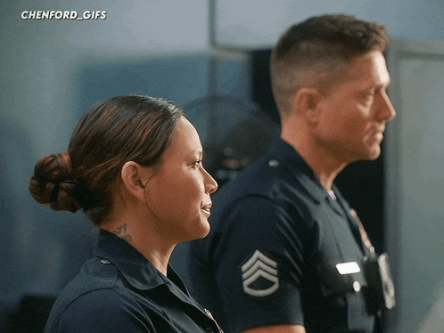 a man and a woman are standing next to each other with a chevron on their sleeve