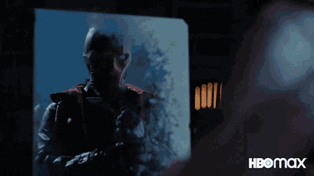 a man in a mask stands in front of a screen that says hbo max