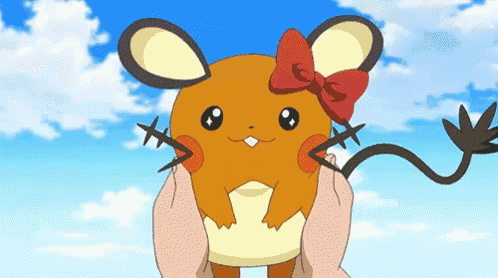 a person is holding a small cartoon character with a red bow on its head