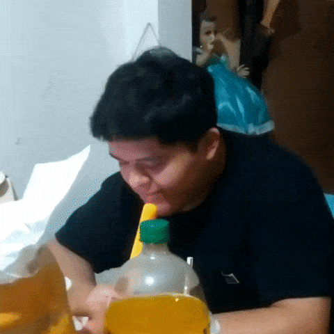 a man drinking from a bottle that has a green cap